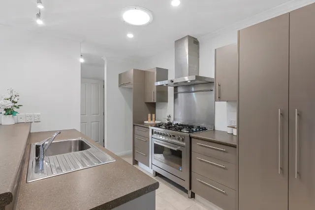 Staged kitchen with cooktop and range hood